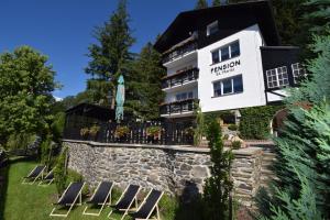 Pension St. Moritz في زيليزنا رودا: فندق فيه كراسي امام مبنى