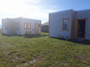 two houses with two dogs standing next to them at Cabañas Frange in Puerto Natales