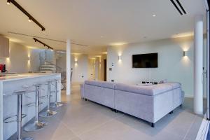 a large living room with a couch and a bar at Luxury 3bd penthouse with roof terrace and hot tub in Canford Cliffs