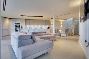 a living room with a couch and a kitchen at Luxury 3bd penthouse with roof terrace and hot tub in Canford Cliffs