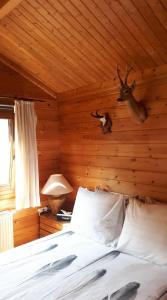 a bedroom with a bed with a deer head on the wall at House Rhodopi in Maldegem