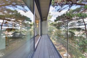 a glass house with a view of the trees at Luxury 3bd penthouse with roof terrace and hot tub in Canford Cliffs