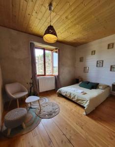 a bedroom with a bed and a wooden ceiling at Le Grenier à Blé in Satillieu