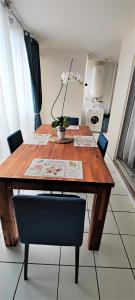 una mesa de madera con sillas en la cocina en T2 Zen Évasion tout confort climatisé Saint Denis, en La Montagne