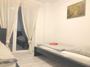 1 dormitorio con cama y ventana con espejo en Work & Stay Apartment in Troisdorf, en Troisdorf