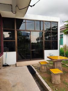 a building with a table and benches in front of it at Homestay Melaka Urich in Melaka