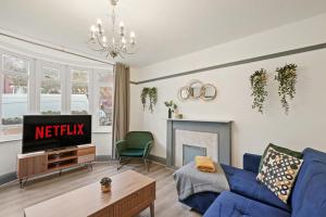 a living room with a blue couch and a tv at Stylish 4 Bed House in Nottingham - sleeps 15 in Nottingham