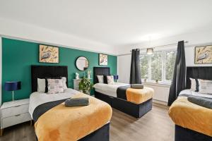 2 camas en una habitación con paredes verdes en Stylish 4 Bed House in Nottingham - sleeps 15, en Nottingham