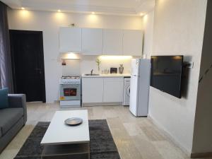 uma pequena cozinha com um frigorífico branco e uma mesa em Deir Ghbar-Studio em Amã