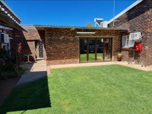 einen Hof vor einem Backsteingebäude in der Unterkunft Chrisand Guesthouse in Kuruman