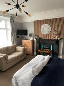a bedroom with a bed and a couch and a fireplace at Bodalwyn Guest House in Aberystwyth