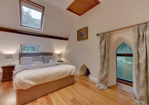 a bedroom with a large bed and an arched window at Oystermouth Chapel in Newton