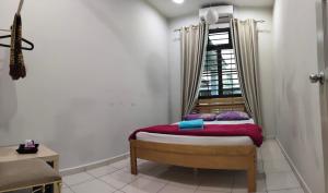 a small bed in a room with a window at Homestay Melaka Urich in Melaka