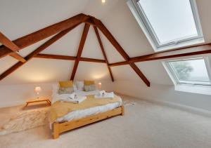 a bedroom with a bed and two windows at Malt Hall in Llanrhidian