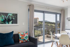a living room with a couch and a balcony at The Paragon Urbane CENTRALLY LOCATED, MODERN COMFORTS in Cape Town