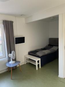 een slaapkamer met een bed en een tafel en een televisie bij Hotell Silverborgen in Sala