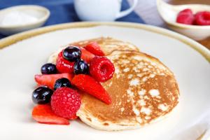 a plate of pancakes with berries and strawberries at Woodlands Farm in Osmotherley