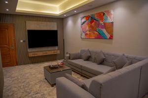 a living room with a couch and a flat screen tv at Rawabi Garden Inn in Jeddah