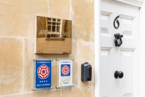 a sign on a wall next to a door at Abbey Mews in the heart of Bath in Bath