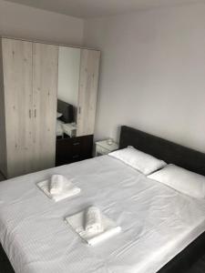 Una cama blanca con dos toallas encima. en Ilinca-ZGATIA en Piatra Neamţ