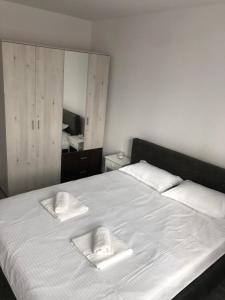 Una cama blanca con dos toallas encima. en Ilinca-ZGATIA, en Piatra Neamţ 8 fotos más