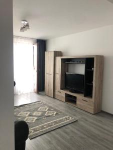 a living room with a large entertainment center with a television at Ilinca-ZGATIA in Piatra Neamţ