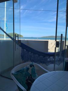 a bathroom with a tub with a view of the beach at Ocean Residence in Palhoça