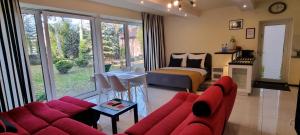 un soggiorno con divano rosso e una camera da letto di Casa Pablo a Jablonna