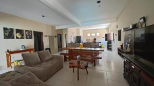 a living room with a couch and a table and a television at Casa Laguna - Barra Jacuípe in Camaçari