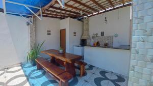 a kitchen with a wooden table and a bench at Casa Laguna - Barra Jacuípe in Camaçari