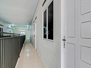 einen Flur mit einer weißen Tür und einem Hallwayngth in der Unterkunft OYO 91847 Rumah Singgah Kinaya Syariah in Parit