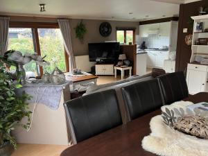 a living room with a couch and a table at Veluwe Park Reewold Chalet Infinity in Putten