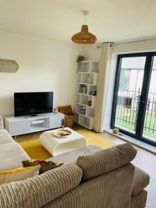 a living room with a couch and a tv at Salt Yard Apartment, Parking and Terrace, Whitstable in Whitstable