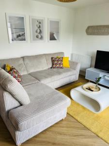 a living room with a couch and a table at Salt Yard Apartment, Parking and Terrace, Whitstable in Whitstable