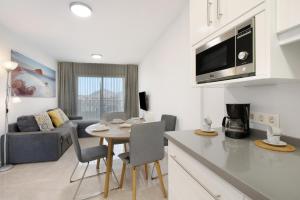 a kitchen and living room with a table and a couch at La Perla F14 By Médano Rentals in El Médano