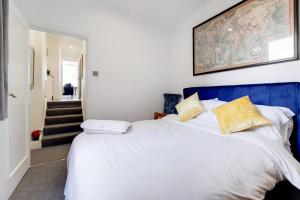 um quarto com uma grande cama branca com almofadas amarelas em Immaculately presented 1 bed em Londres
