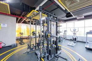 a gym with rows of exercise equipment in a room at bnbmehomes - Cosy Downtown Apt w Balcony Near Metro Station -1710 in Dubai