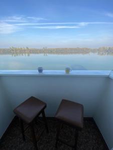 a pair of stools sitting in front of a lake at Danube in Vukovar