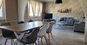 uma sala de estar com uma grande mesa de madeira e cadeiras em Maison familiale à Haybes em Haybes