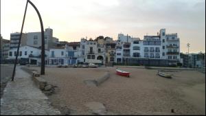 a beach with white buildings and boats on the sand at Apartamento primera línea de Mar Enjoy the view in Blanes
