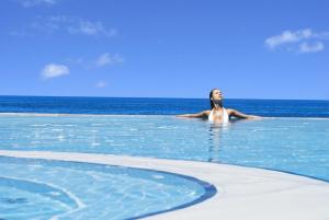 a woman in a swimming pool in the ocean at Charisma De Luxe Hotel in Kuşadası