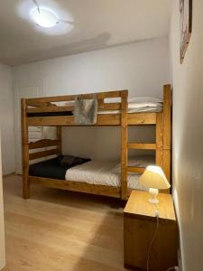 two bunk beds in a room with a table and a lamp at Appartement 65m² idéalement placé pour 6 pers. in Brides-les-Bains