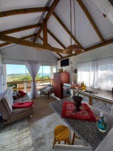 Il dispose d'une cuisine et d'un salon avec un canapé et une table. dans l'établissement Apartamento Praia da Gamboa - Cabanas da Candoca Vista para o Mar, à Garopaba