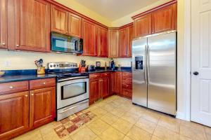 a kitchen with wooden cabinets and a stainless steel refrigerator at Bayside Resort --- 36288 Sunflower Blvd in Selbyville