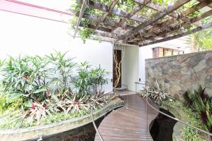 un patio con plantas y una pasarela de madera en Rumah Pelita near Lembang FREE WIFI - Villa Lantera, en Bandung