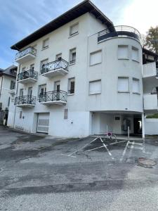 a white building with balconies and a parking lot at Appartement 65m² idéalement placé pour 6 pers. in Brides-les-Bains