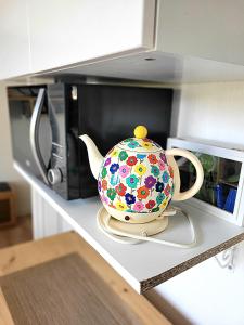 a tea pot sitting on the counter of a microwave at Diamant Studio classé 3 Étoiles in Saint-Germain-en-Laye