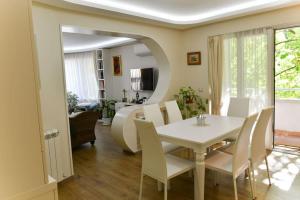 een eetkamer met een witte tafel en stoelen bij Аристократичен апартамент в сърцето на Ямбол in Yambol