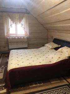 a bed in a small room with a window at Біля комори in Pilipets