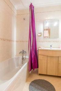 Łazienka wyposażona jest w fioletową zasłonę prysznicową, wannę i umywalkę. w obiekcie Albufeira Old Town Two bedroom Apartment Center w Albufeirze